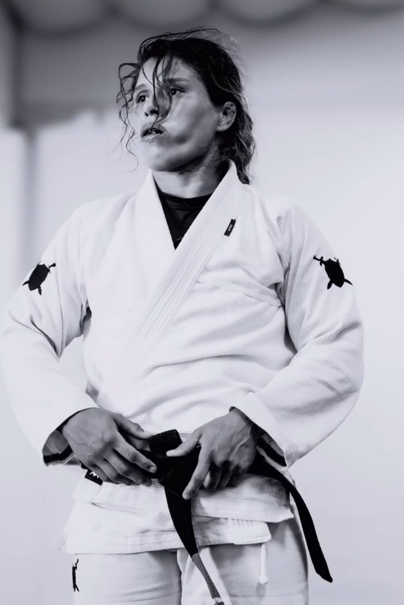 Gabi McComb in the gi, tying her black belt