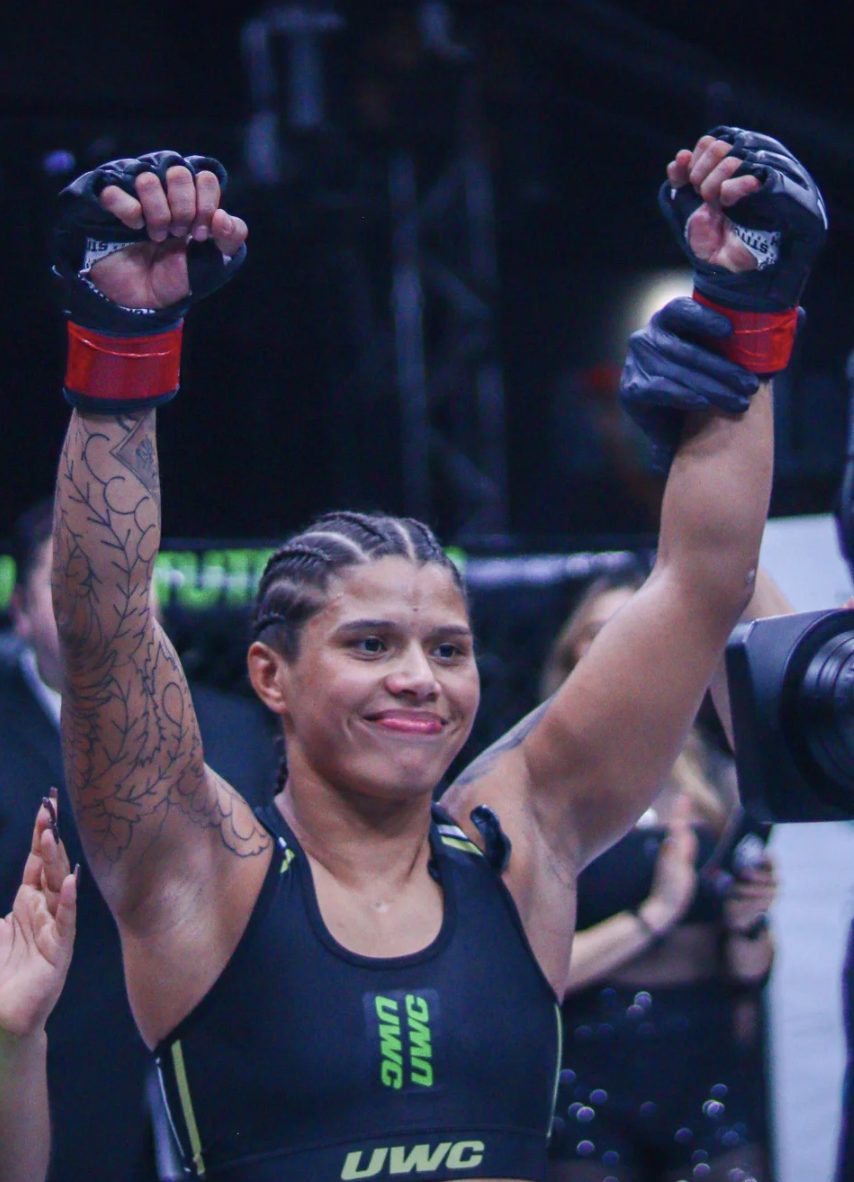 Gabi McComb celebrating a first-round submission win in the cage